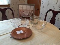 Overview of all items on table showing Dublin Crystal serving set in box, Nachtmann crystal bowl, vintage glass compote dish with lid, and copper sweets server with handle.