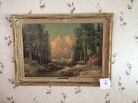 Front view of signed Robert Wood print with detailed nature scene and full ornate wood frame against floral wallpaper.