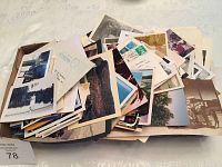Box filled with various postcards, many with postage stamps and handwritten notes