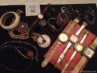Photo showing entire assortment of bone bracelets, watches, beaded jewelry, rings and brooch, arranged together.