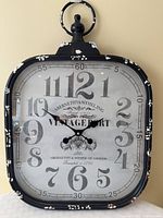 Front view of clock showing dial, frame, branding, distressing