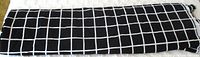 Folded length of black fabric with white grid check pattern
