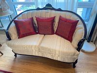 Front view of loveseat with three red pillows