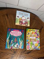 All three coloring books laid out on table: Cozy Days, Magical Mermaids & More, Crayola Epic Book of Awesome