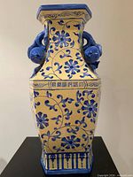 Full frontal view of hexagonal vase showing blue floral decoration on yellow ground