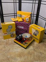 Group view: Brownie Starmatic and accessory boxes, Brownie Hawkeye flash kit box with camera and bulbs, safelight filter box, leather case partially visible