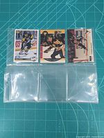 Front view of three Mario Lemieux trading cards in protective sleeve