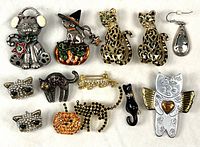 Full layout of 13 cat-themed jewelry pieces