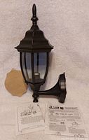 Front view of black wall-mount lantern with accessories