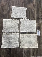 All five rectangular crochet doilies laid out on floor