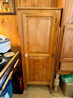 Front view of solid wood cabinet with single door and porcelain knob
