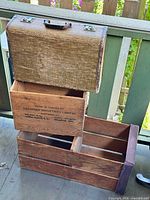 Stacked view of suitcase on explosives crate on slatted crate