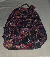 Front view of Lighten Up Midnight Wildflowers backpack showing floral pattern and zip compartments