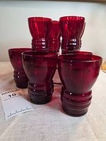 Front view of eight ruby red tumblers showing color and ribbed bases