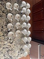 Twenty-four tall mugs arranged on countertop, view of interiors showing Christmas tree motif