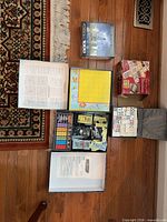 All items laid out: Spy Alley game box open, puzzle box, bingo cage box, dominoes case, children’s board game board
