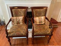 Front view of both matching upholstered armchairs with pillows