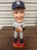 Front view of Whitey Ford ceramic bobblehead on red base