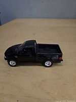 Left side view of black Ford F-150 die-cast truck