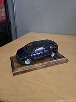 Front three-quarter view of blue Plymouth Voyager die-cast model on wood base