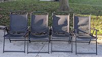 Group shot of four black folding patio chairs side by side