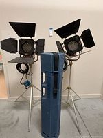 Front view of both spotlights on stands with case