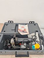 Plate joiner, cord, bottle, case interior, manual visible