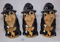 Front view of three identical witch toppers