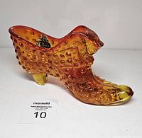 Left side profile of orange hobnail glass shoe figurine