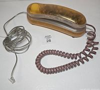 Top view of transparent orange phone with cords