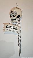 Front view showing full sign with text and hanging loop