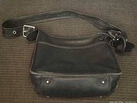 Full view of black leather Coach shoulder bag with strap