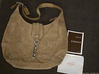 Full view of Coach tan suede hobo bag with paperwork