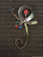 Front of sterling brooch showing multicoloured stones and ribbon design
