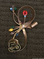Front view of ribbon bouquet brooch showing stones and oval tag