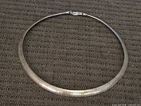 Full view of sterling silver snake chain necklace laid flat