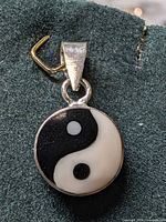 Front view of round silver pendant with yin-yang symbol