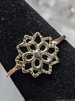 front view of floral silver ring on display stand