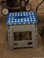 Front view of blue and gray folding step stool showing non-slip top and legs