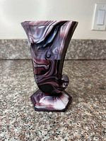Front view of swirled glass vase showing color pattern and curled scroll accent