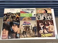 Nine album sleeves on tabletop, full lot overview