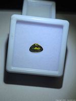 Front view of pear cut yellow-green sapphire in gem box