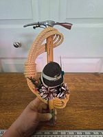Front view showing full length, rope coil, hat, pine cones and ruler for scale