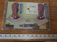 Front view of sealed Tramontina Polywood mezzaluna knife with ruler for scale