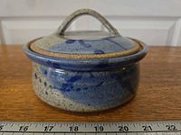 Front view of stoneware casserole with lid on, showing glaze pattern and scale for size