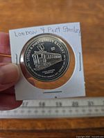 Obverse of token in 2x2 holder showing engraved electric car and inscriptions