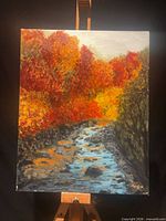 Full view of signed acrylic landscape painting on easel
