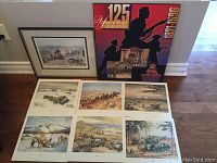 Photo shows framed Andre Castaigne print and large 125 Years of Service commemorative print with six Joan Wankyn prints arranged below.