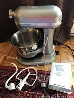Mixer with bowl, attachments and manual laid out