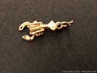 Close-up of the gold lobster pendant showing front detail and shape.